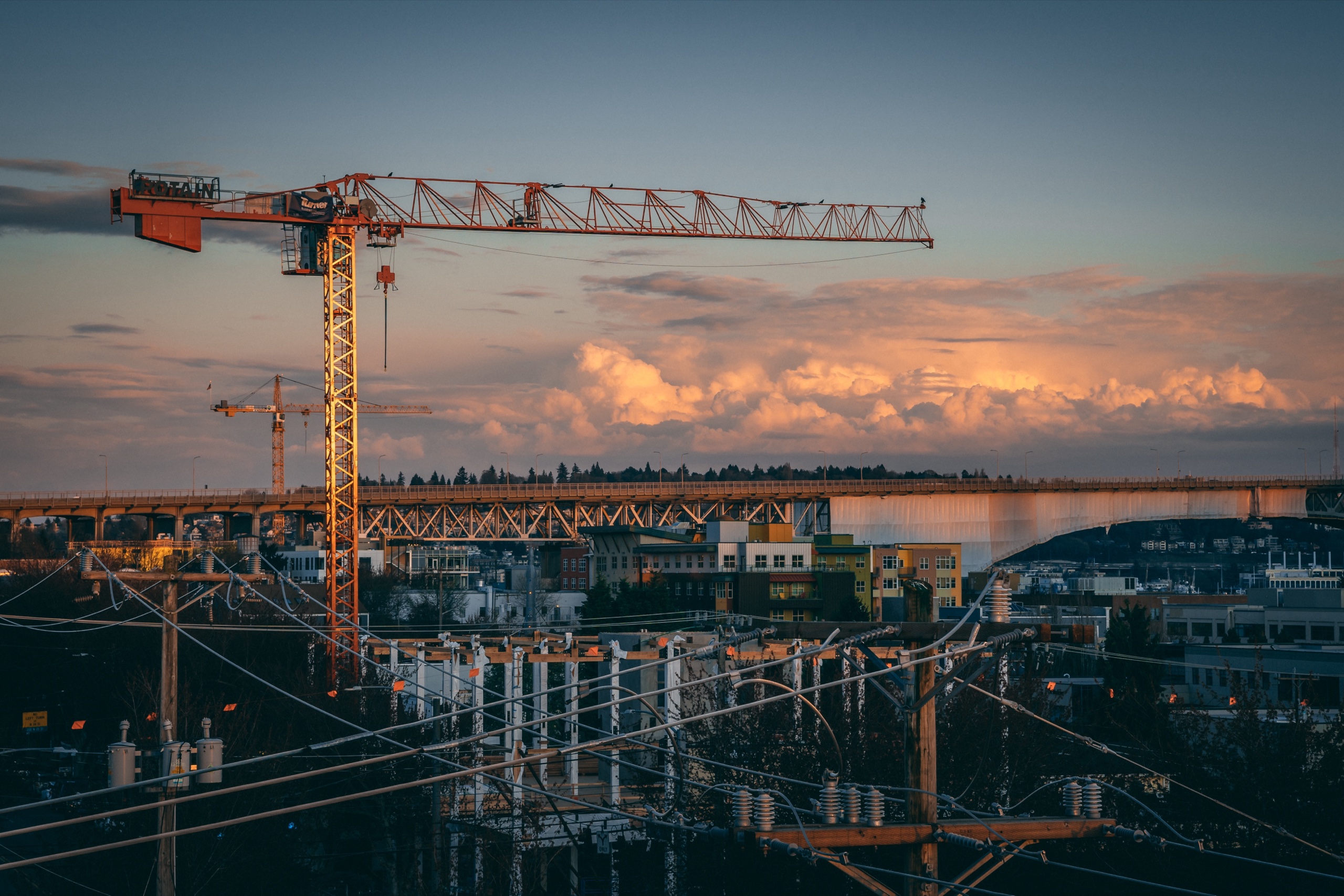 Grue sur un chantier urbain au coucher du soleil